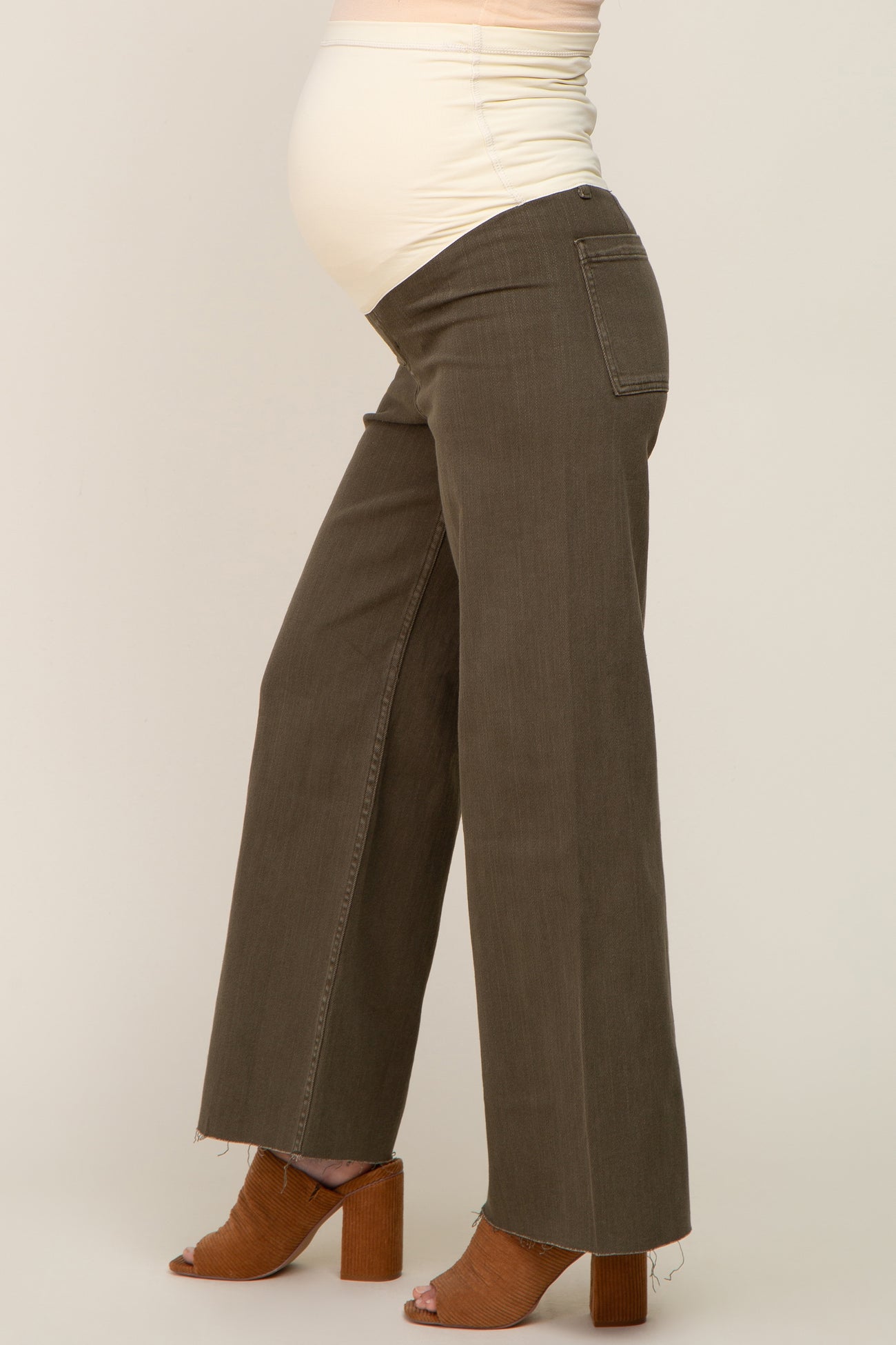woman wearing olive green wide-leg maternity jeans and showing her baby bump