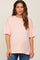 woman wearing a light peach oversized maternity t-shirt with short sleeves and a pocket on the front
