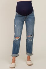 woman wearing distressed blue maternity jeans with a navy blue belly panel and rolled cuffs
