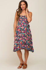 woman wearing a floral maternity dress with a smocked bodice and ruffled hem, showcasing her baby bump