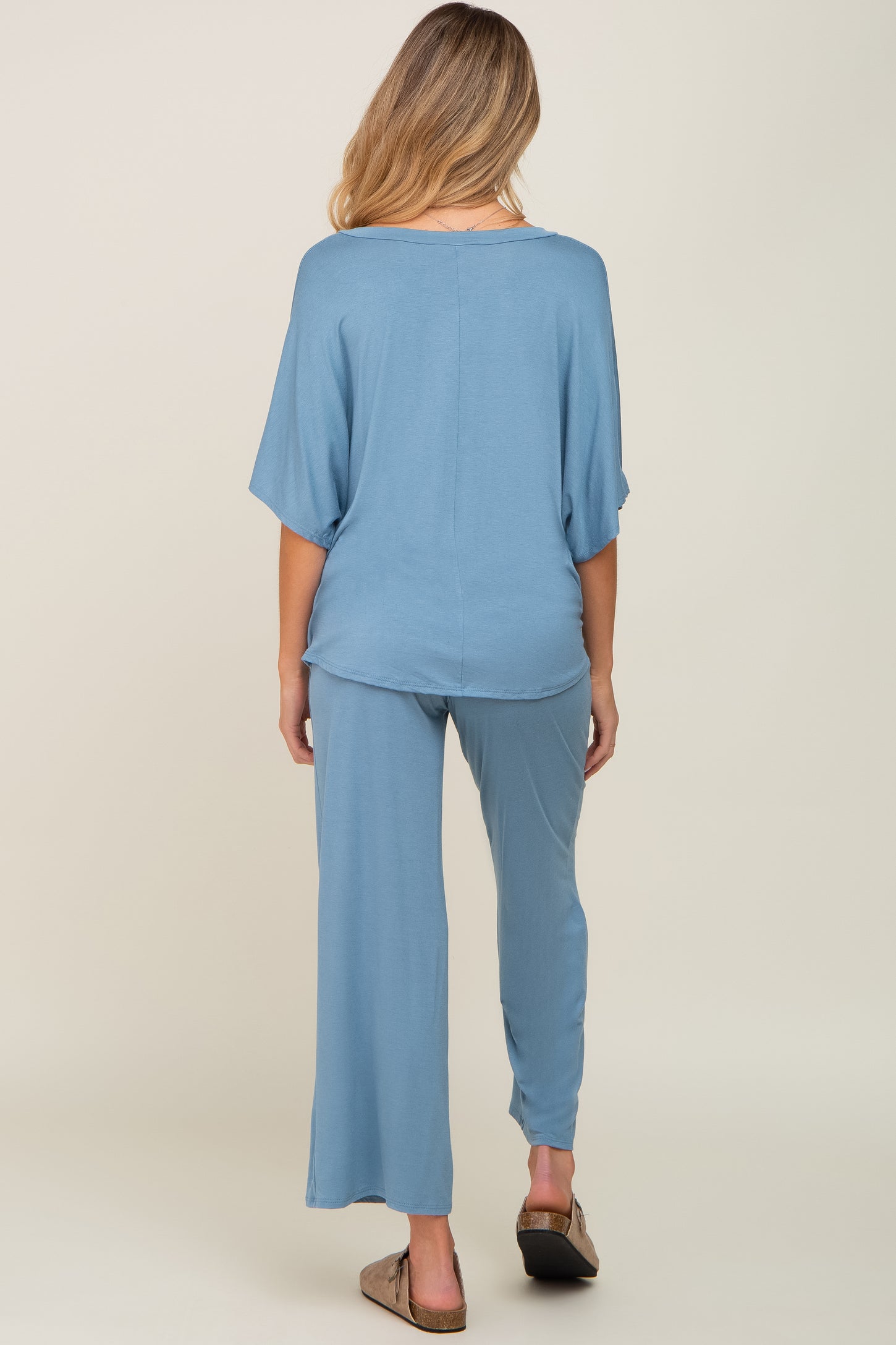 woman wearing a light blue maternity lounge set with wide-leg pants and a loose top, showing a relaxed fit from the back