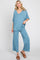 woman wearing blue v-neck short sleeve top and matching wide leg lounge pants with brown sandals