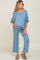 woman wearing a blue maternity lounge set with a v-neck top and wide-leg pants, showing her baby bump