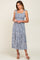 woman wearing a blue floral midi dress with tie straps and smocked bodice