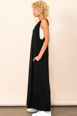 woman wearing a black sleeveless maxi dress with pockets and white sneakers