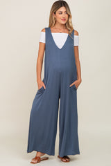 woman wearing a slate blue maternity jumpsuit with pockets and off-shoulder white top, baby bump visible