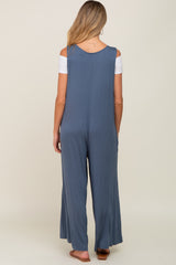 woman wearing a blue maternity jumpsuit with a loose fit and open shoulders, viewed from the back
