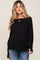 woman wearing a black long sleeve maternity top and showing her baby bump
