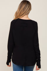 woman wearing a black long sleeve maternity top with a relaxed fit and back detail