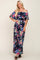 woman wearing a navy off-the-shoulder maxi dress with a vibrant floral print and flowing sleeves