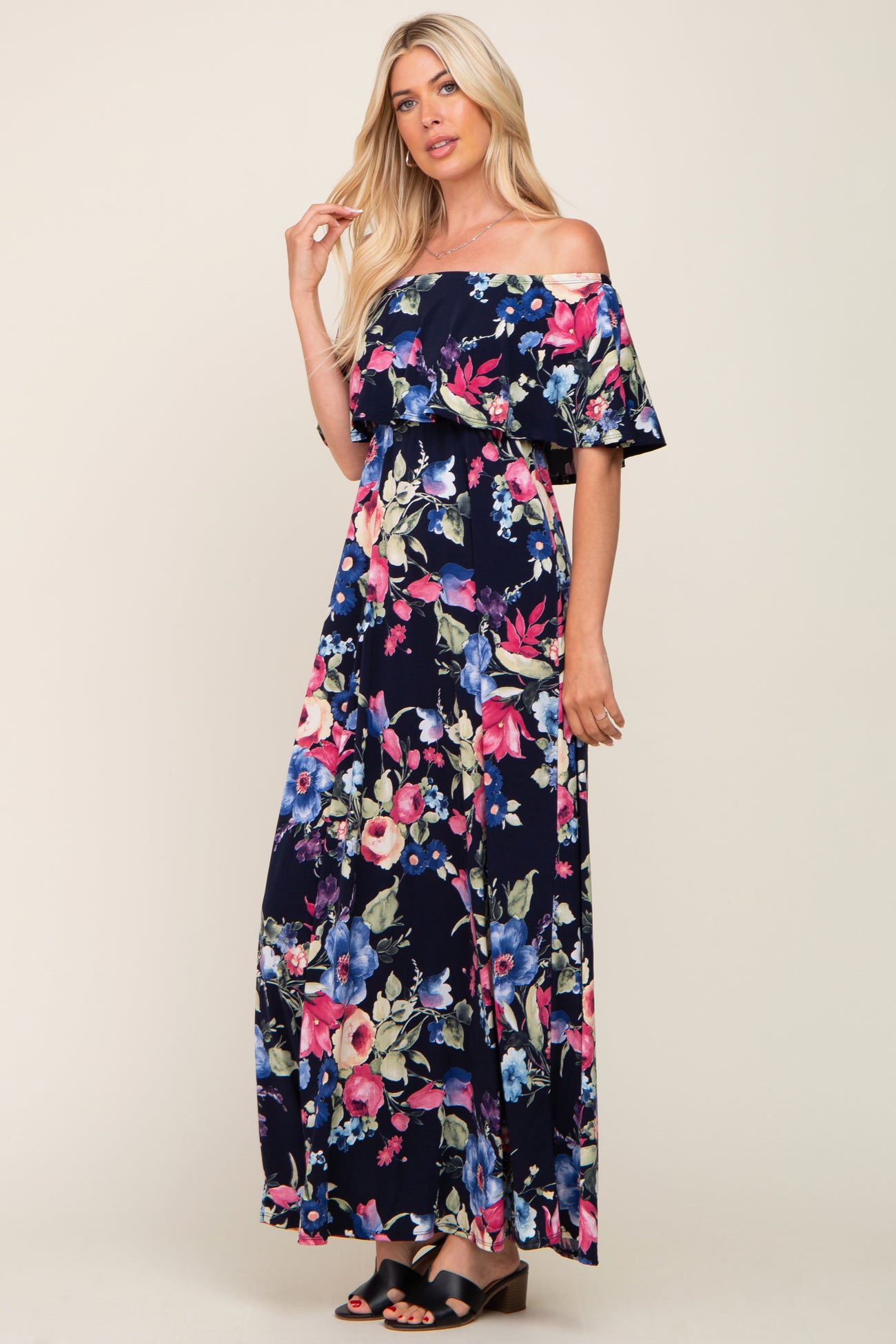 woman wearing a navy floral off-the-shoulder maxi dress with colorful blossoms and relaxed fit