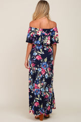 woman wearing a navy floral off-the-shoulder maternity maxi dress, seen from the back