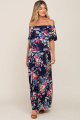 woman wearing a navy floral off-the-shoulder maxi maternity dress with a flowing silhouette and visible baby bump
