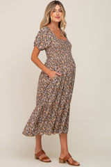 woman wearing a floral maternity dress with short puff sleeves and pockets, showcasing her baby bump
