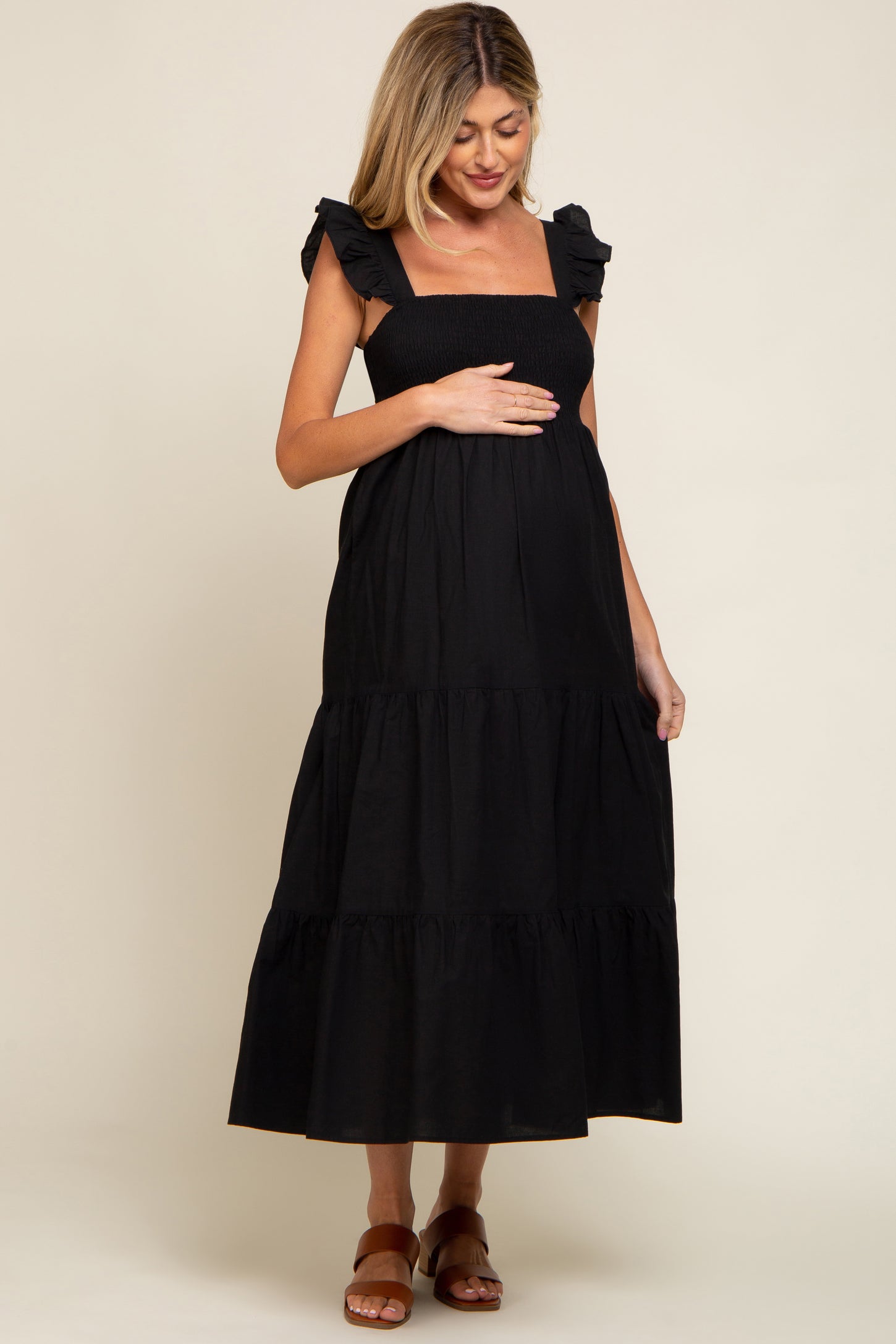 woman wearing a black maternity maxi dress with ruffled sleeves and a baby bump visible