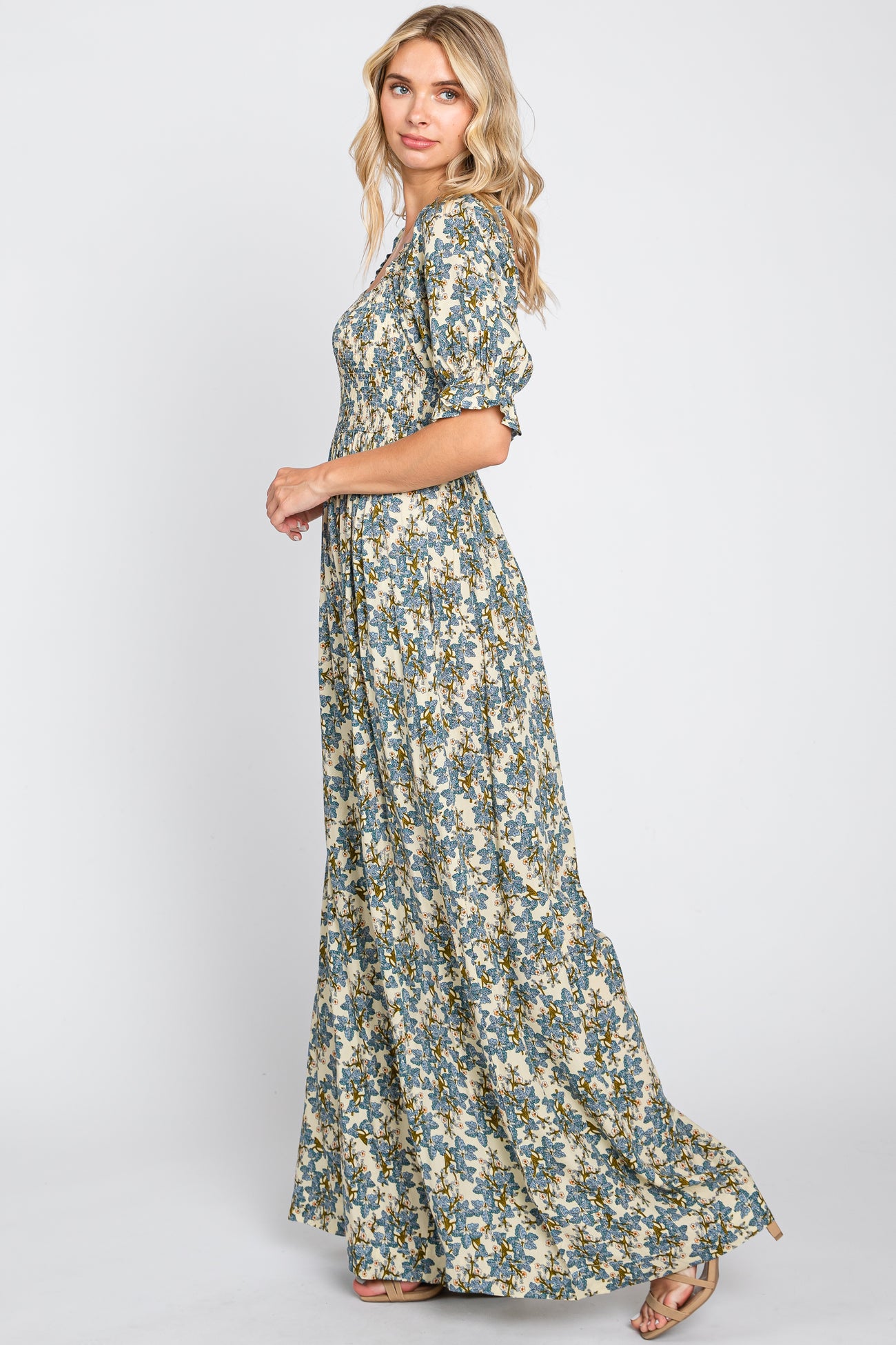 woman wearing a long floral maxi dress with puff sleeves and a cinched waist