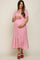 woman wearing a pink floral maternity dress with short sleeves and a tiered skirt, holding her baby bump