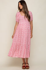 woman wearing a pink floral maternity maxi dress with short puff sleeves and a square neckline
