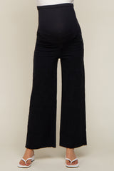 pregnant woman wearing black wide leg maternity jeans with over the belly support band