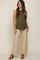 woman wearing a dark green ribbed maternity tank top and beige wide-leg pants, with a baby bump visible