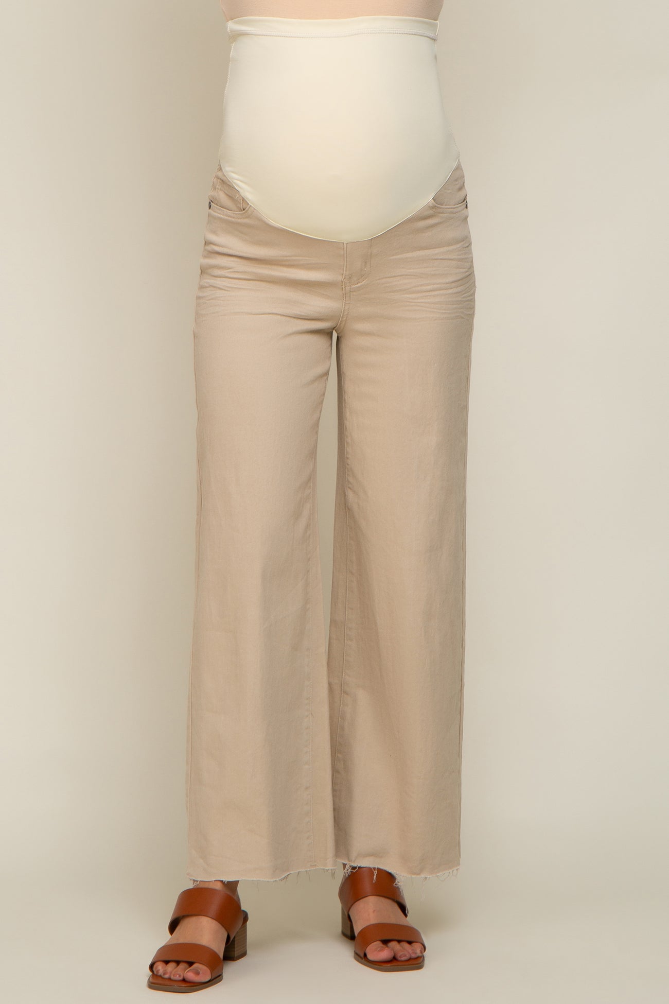 woman wearing beige maternity jeans with a supportive belly band and wide leg fit