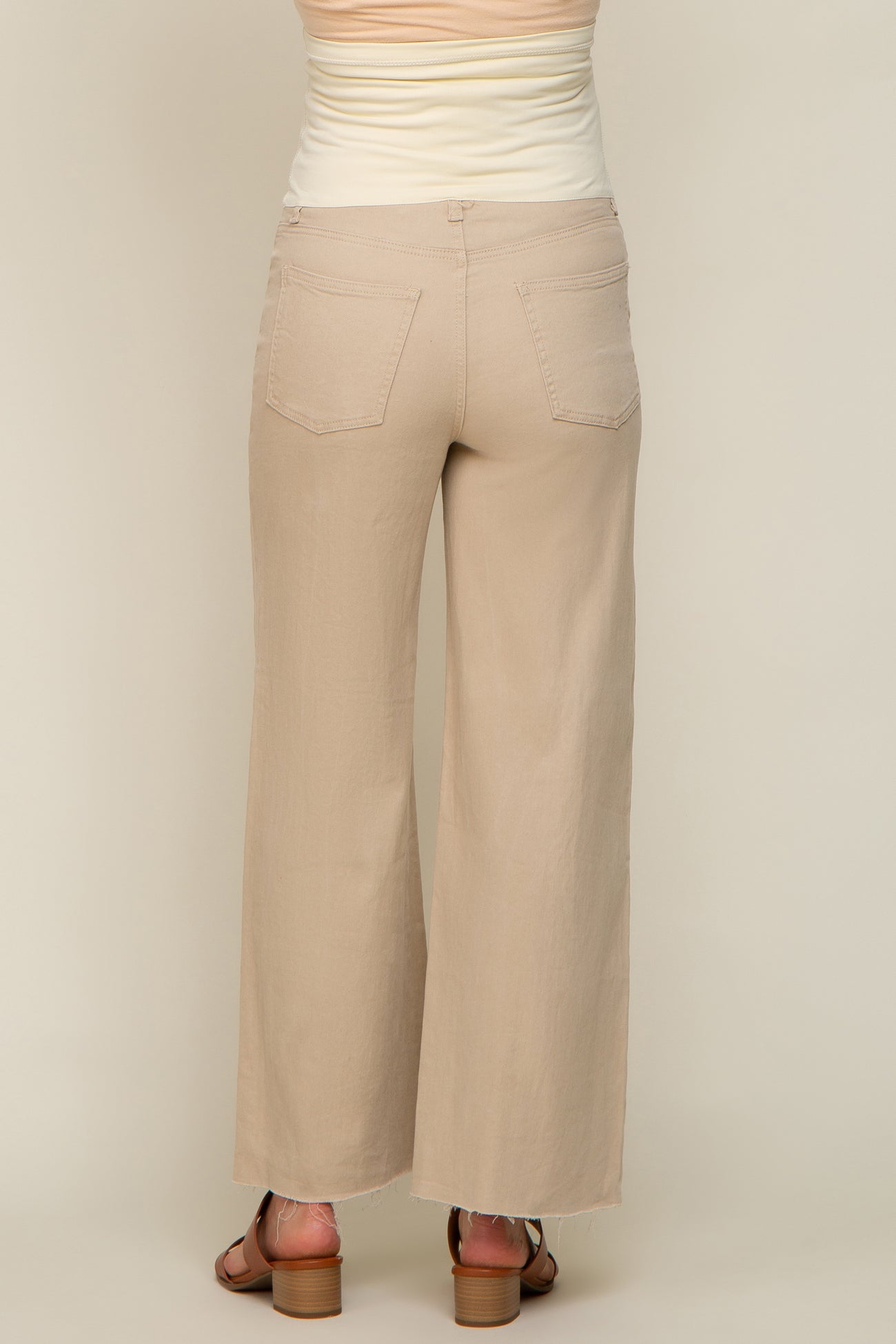 woman wearing beige wide-leg maternity pants, viewed from the back