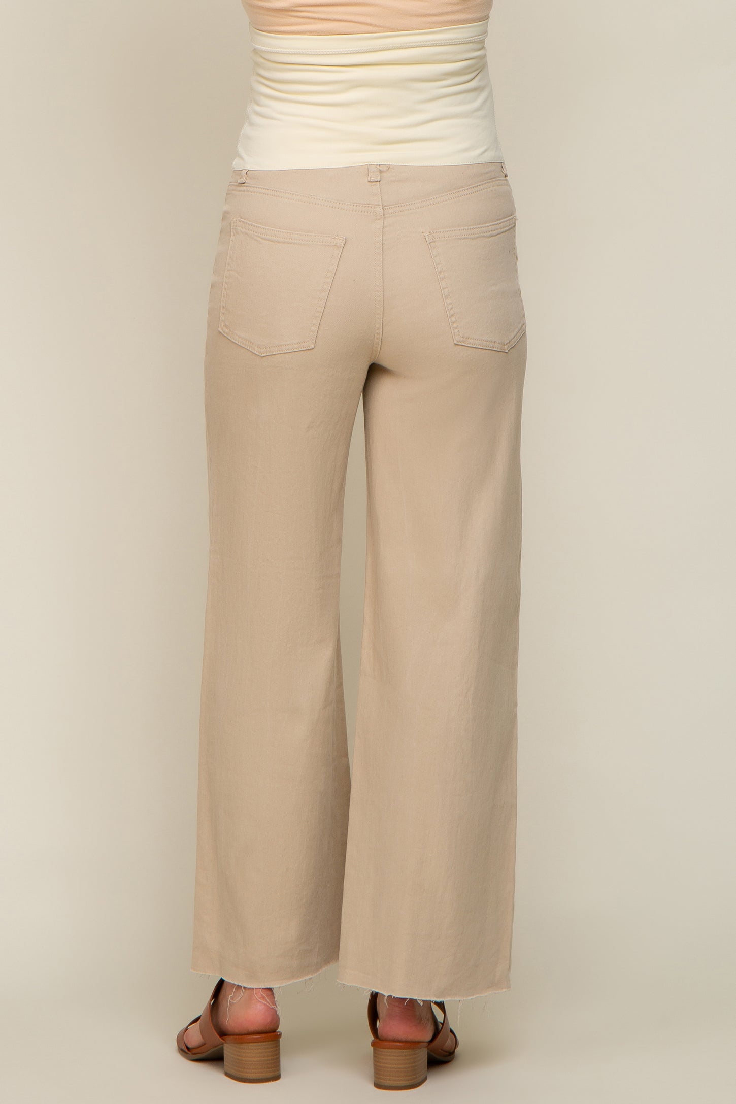 woman wearing beige wide-leg maternity pants, viewed from the back