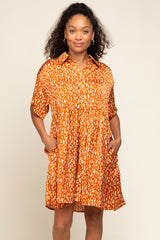 woman wearing an orange short sleeve button-up dress with a relaxed fit and front pockets