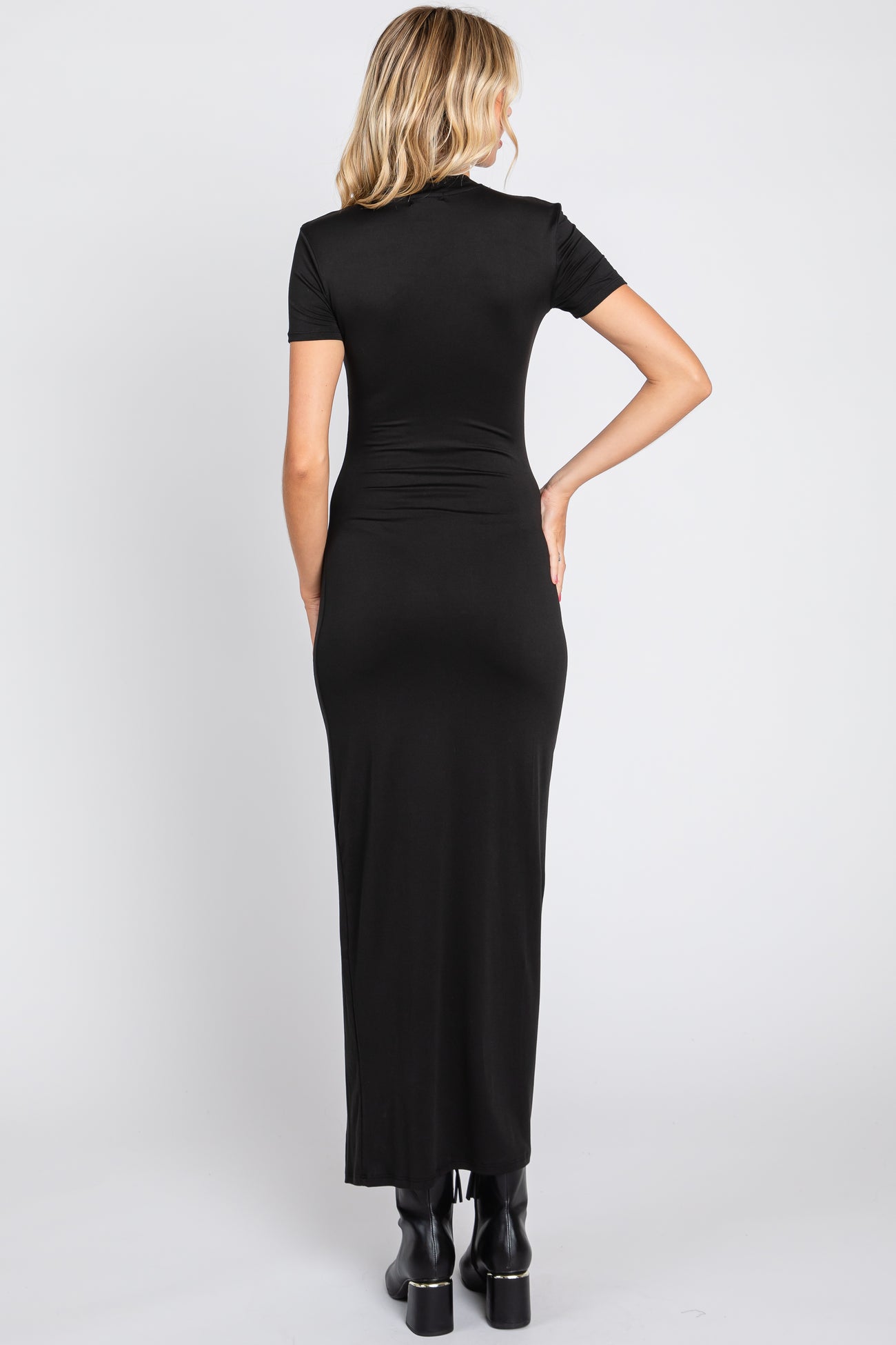 woman wearing a fitted black maxi dress with short sleeves and a sleek silhouette, viewed from the back
