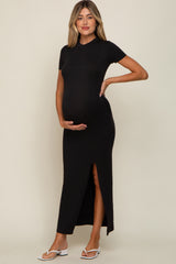 woman wearing a black short sleeve maternity maxi dress with a side slit and holding her baby bump