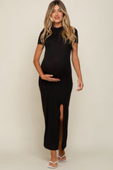 woman wearing a black maternity maxi dress with a side slit and holding her baby bump