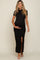 woman wearing a black maternity maxi dress with a side slit and holding her baby bump