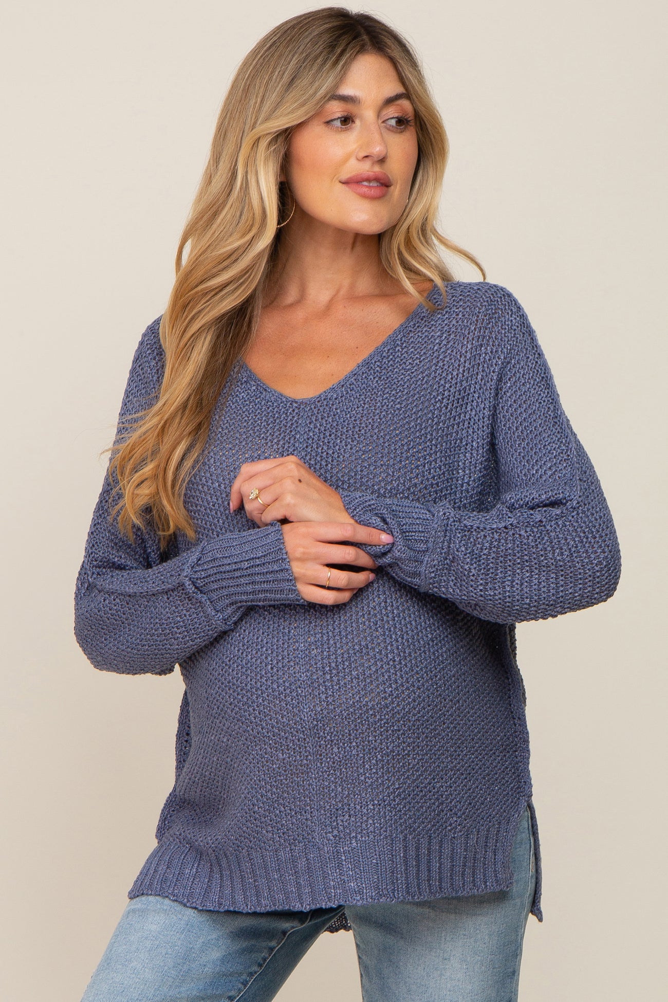 woman wearing a relaxed fit dark blue v-neck maternity sweater with side slits and a visible baby bump