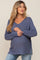 woman wearing a relaxed fit dark blue v-neck maternity sweater with side slits and a visible baby bump