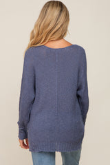 woman wearing a long sleeve navy maternity sweater, showing the back view and relaxed fit