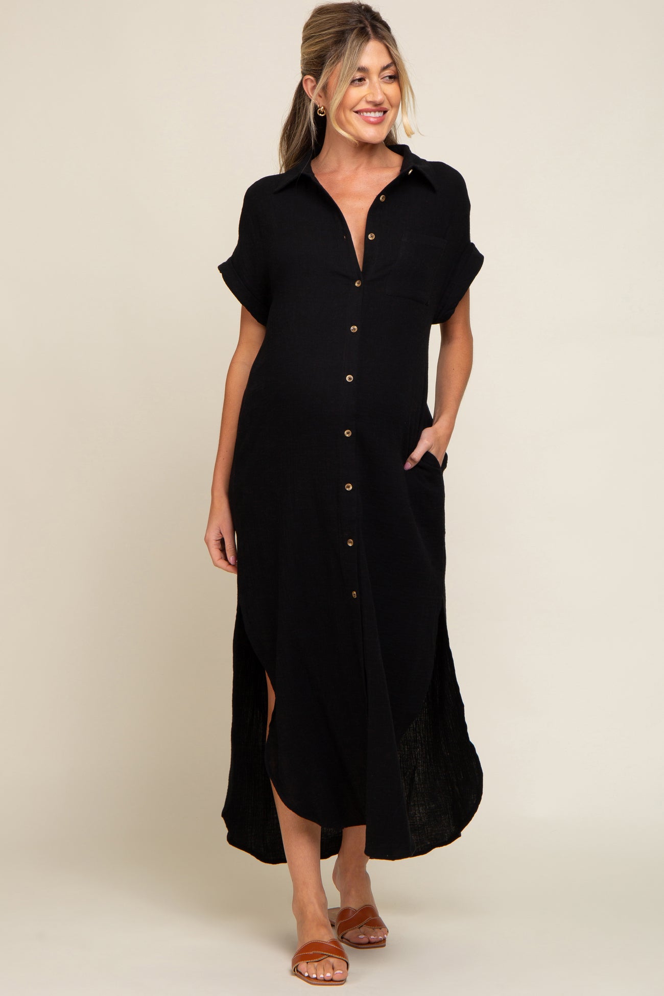 woman wearing a black short sleeve button-up maternity dress with a relaxed fit and side slits