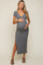 woman wearing a gray short sleeve maternity dress with a side slit and holding her baby bump