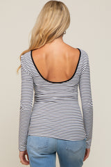 woman wearing a striped maternity top with a low back and long sleeves, paired with light blue jeans