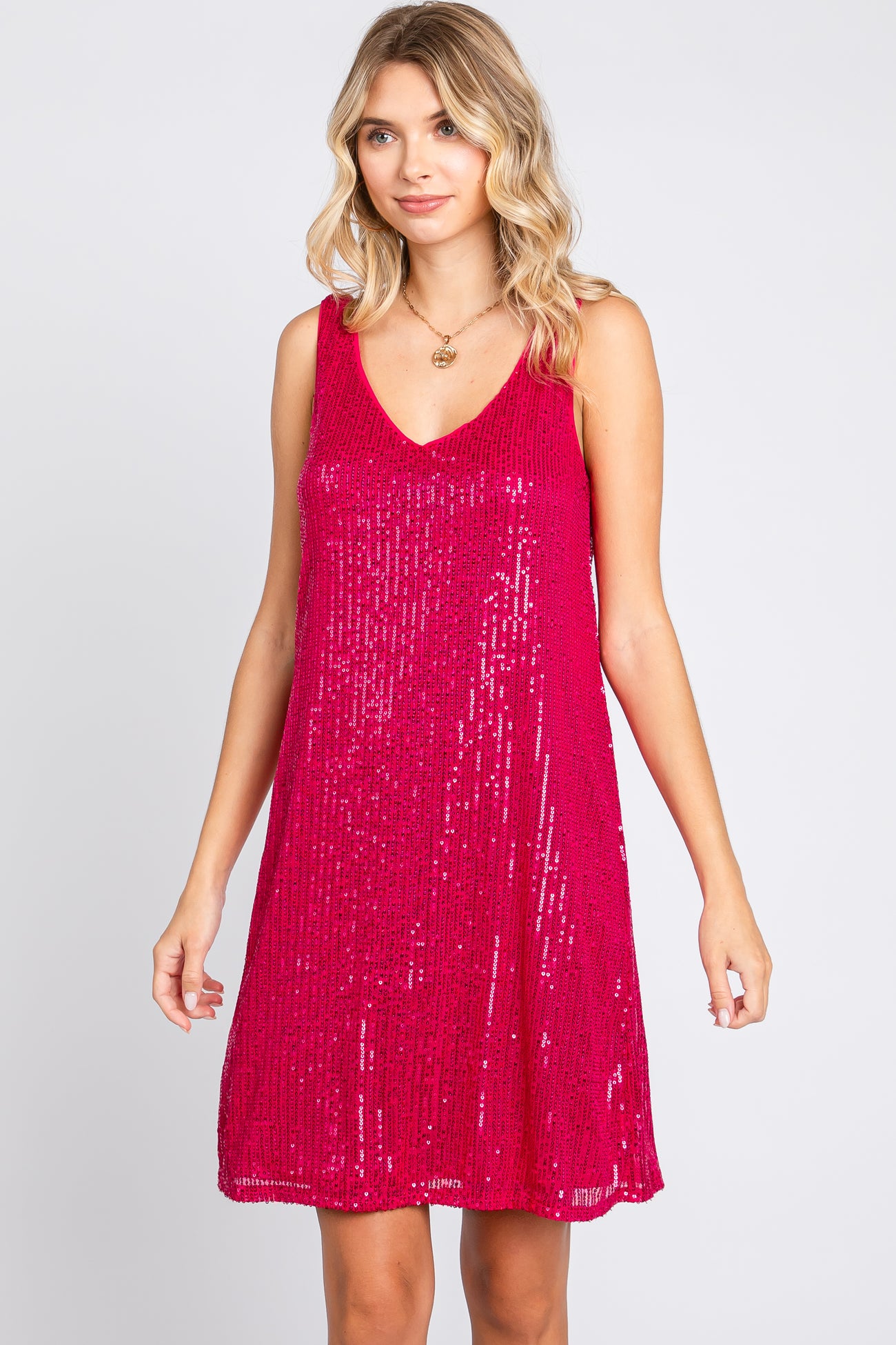 woman wearing a hot pink sequin sleeveless dress with a v-neckline and a relaxed fit