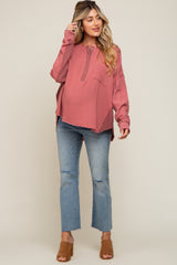woman wearing a coral long sleeve waffle knit maternity top with buttons and pocket, paired with distressed light wash maternity jeans and heels