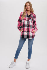 woman wearing a pink and black plaid button-up shirt with pockets and blue skinny jeans