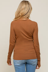 woman wearing a rust long sleeve maternity top with shirring detail, viewed from the back