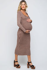 woman wearing a brown ribbed knit maternity dress with a fitted silhouette and holding her baby bump