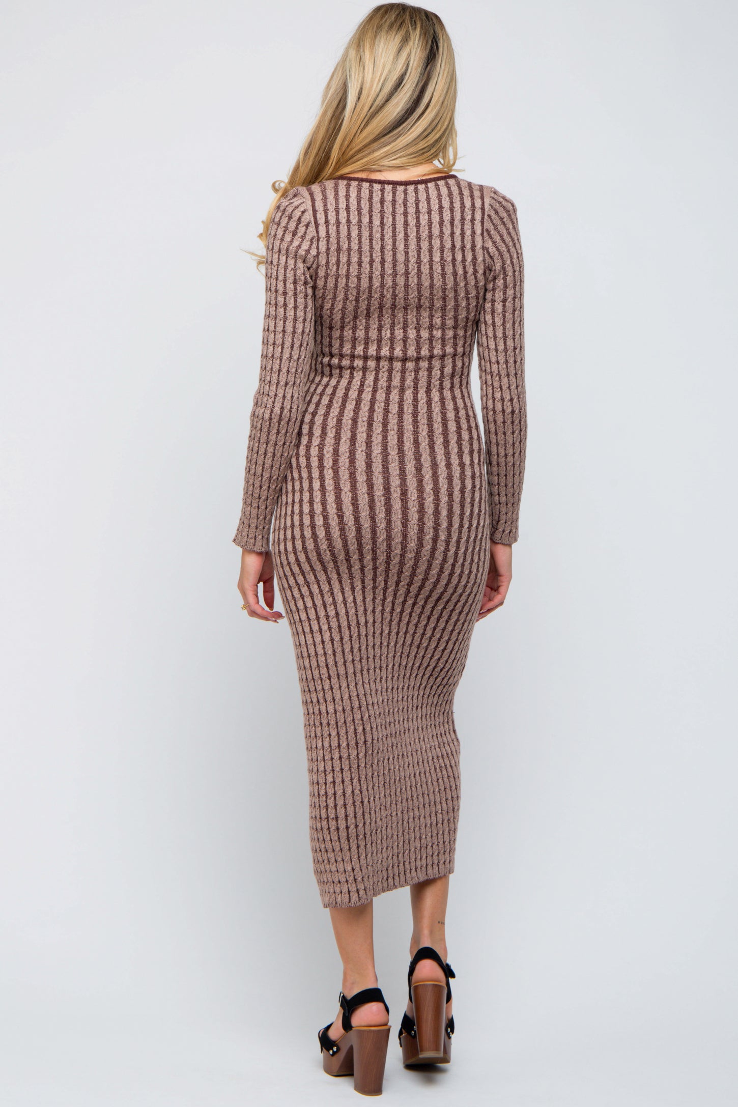 woman wearing a brown striped long sleeve maternity dress, showing a baby bump, with a form-fitting silhouette
