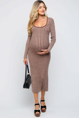 woman wearing a brown ribbed maternity dress with a scoop neckline and holding her baby bump