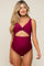 woman wearing a burgundy cutout maternity swimsuit with a twist design and ruched sides, showcasing her baby bump