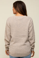 woman wearing a beige maternity sweater with a textured knit and relaxed fit, shown from the back