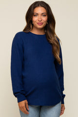 woman wearing a navy blue textured maternity sweater with a round neckline and a relaxed fit over her baby bump
