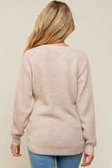woman wearing a soft beige maternity sweater with a textured knit and long sleeves, view from the back