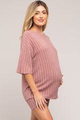 woman wearing a dusty pink ribbed maternity top and matching shorts, showing her baby bump